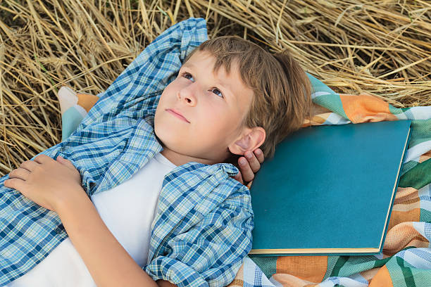 istock Teenage boy lying and dreaming inspired by book 530455301