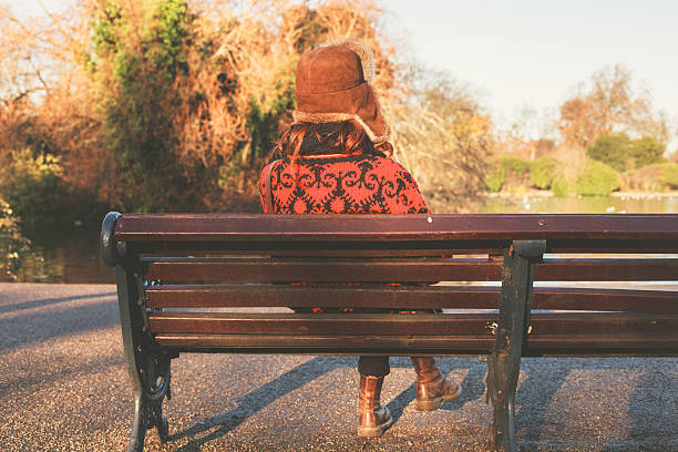 istock Woman in winter hat sitting on bench 530455883