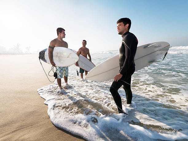 istock Three young surfers ready for surfing. 530456293