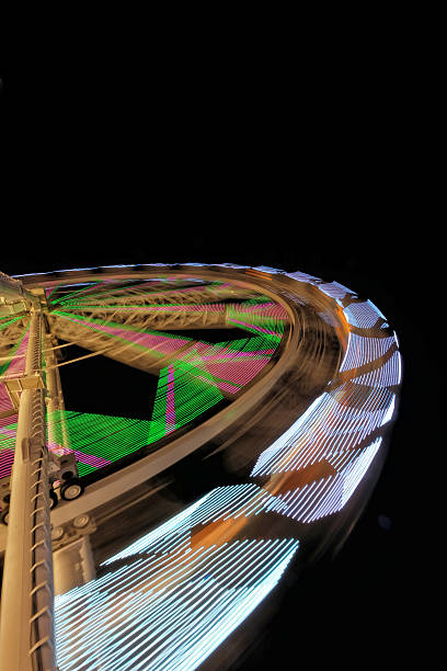 istock Fairground ferris wheel with colorful light trails 530456333