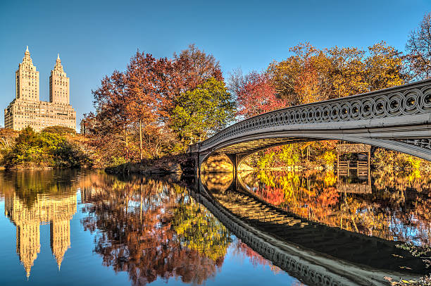 ponte di arco sul cielo blu al giorno - autumn park central park lake foto e immagini stock