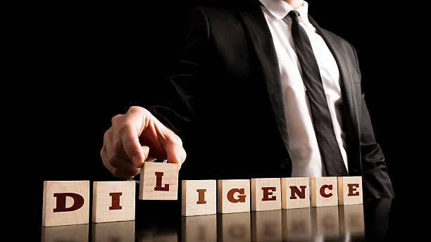 Wooden Pieces with Diligence Text on Black Background Close up Businessman in Black Business Suit Arranging Small Wooden Pieces with Diligence Text on Black Background. assiduity stock pictures, royalty-free photos & images