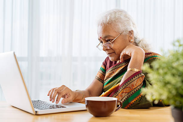 trabajando en la computadora portátil - indian culture women india indian ethnicity fotografías e imágenes de stock