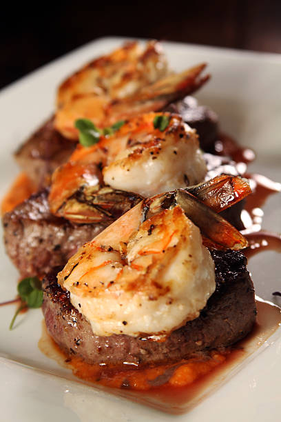 Gourmet shrimp and steak focus on foreground