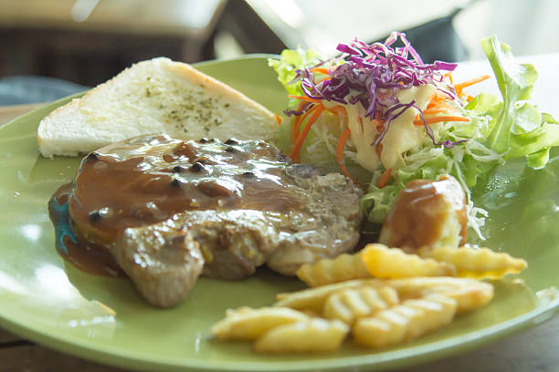istock Grilled pork chop with chips and vegetables. 530468127
