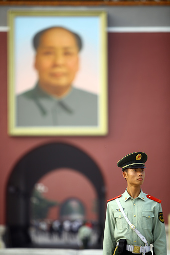 Beijing, China - September 25, 2014:  A soldier stands guard at Tiananmen Square, near a portrait of Mao Zedong, in Beijing, China.