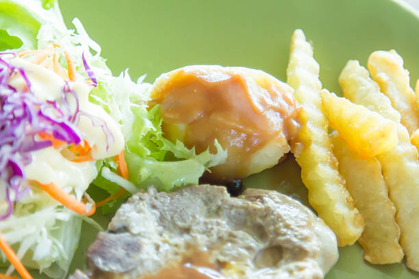 Grilled pork chop with chips and vegetables.
