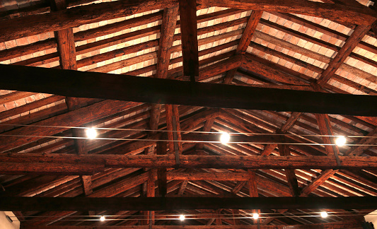 the roof with beams facing bricks and powerful halogen lamps