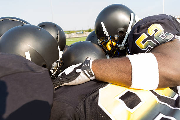 istock Professional football players huddled together on sidelines before game 530479345