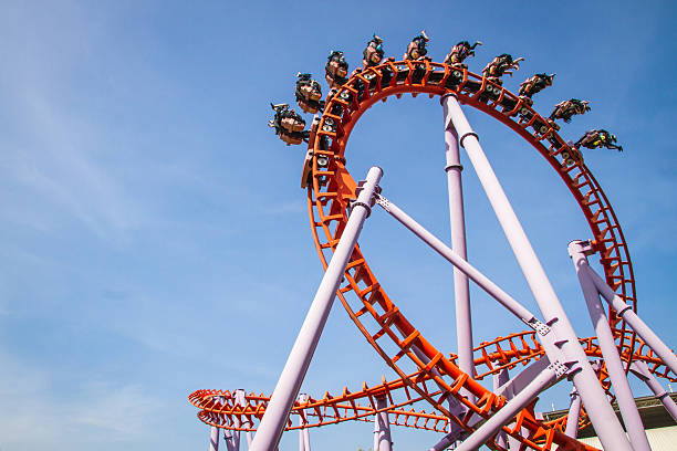 achterbahn vor blauem himmel - rollercoaster stock-fotos und bilder