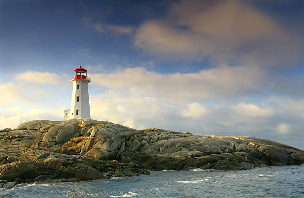 Lighthouse at Peggy's Cove The beautiful lighthouse at Peggy's Cove, Nova Scotia in dramatic morning light. This is one of the most famous lights in Canada and was also the scene of a tragic plane crash in the 90s. The water-worn rocks and dramatic lighthouse clutching the rocks are classic Canadiana. Thousands of people take the short drive from Halifax to visit Peggy's Cove, a classic fishing village, each year.  maritime provinces stock pictures, royalty-free photos & images