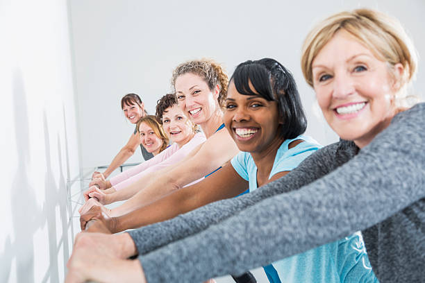 grupo de mulheres, tendo uma aula de exercício físico - fun senior adult aerobics exercise class imagens e fotografias de stock