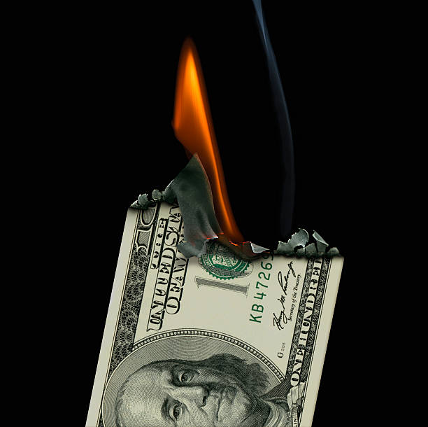istock 100 Dollar Banknote on fire set on a black background. 530484671