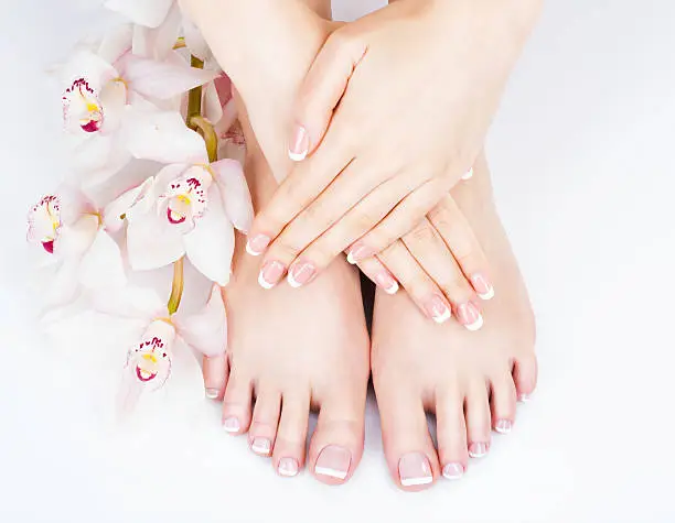 Closeup photo of a female feet at spa salon on pedicure and manicure procedure - Soft focus image