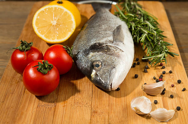 istock Fresh uncooked dorado or sea bream fish with lemon 530491644