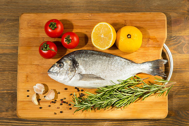istock Fresh uncooked dorado or sea bream fish with lemon 530491740