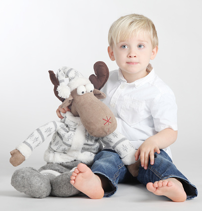  Cute, pretty young boy with pet in studio on white background