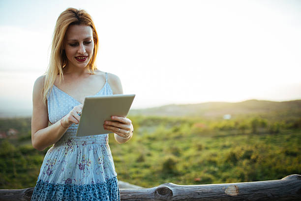 istock Young woman using  tablet outdoors 530493582