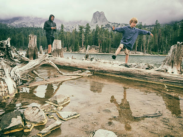 criança equilibrando-se sobre um água em um verão fresco lago de montanha - mammoth - fotografias e filmes do acervo