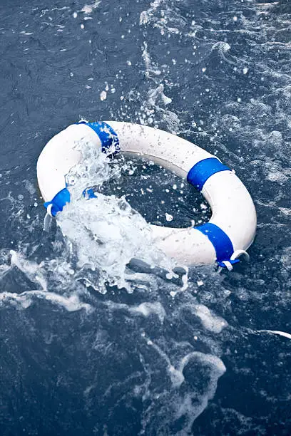 White and blue lifebelt, lifebuoy in a rescue on ocean storm wave