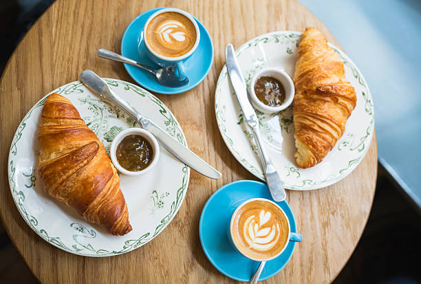 café et un croissant. style français petit déjeuner au café (paris, france) - coffee hot drink cup teaspoon photos et images de collection