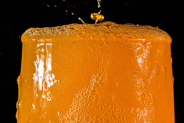 Orange soda large glass close up Orange soda large glass, overflowing glass of orange soda closeup with bubbles isolated on black background orange drink bubbles stock pictures, royalty-free photos & images