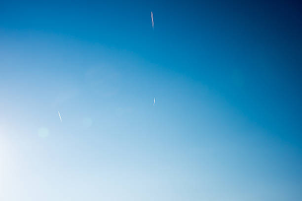 istock Passenger jet planes with a long trail on blue sky 530497330