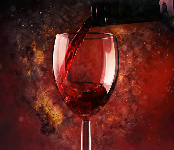 Pouring red wine and fire background stock photo