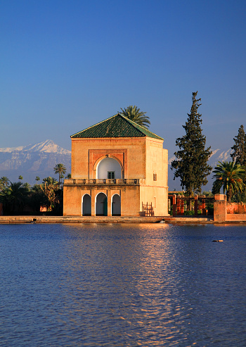 The Menara Gardens and Pavilion, with the snow covered Atlas Mountain range in the background. Marrakesh, Morocco.