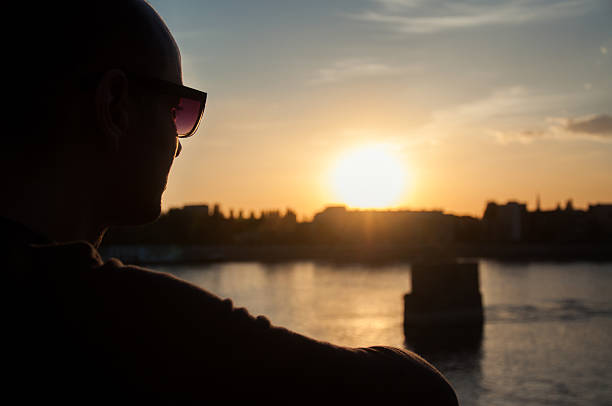istock Man silhouette looking over the city in sunset 530499632