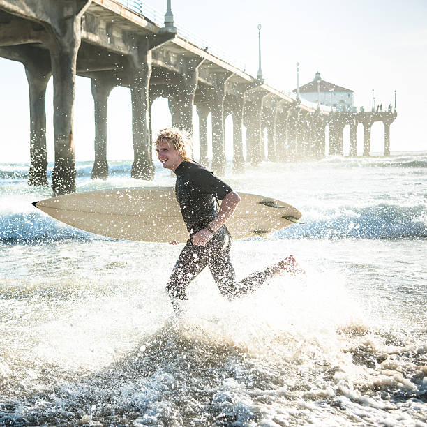 istock surfer running on the beach 530500804