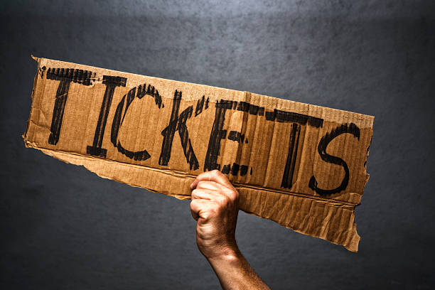 istock Hand holding cardboard sign with Tickets written on it 530502214