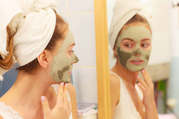 istock Woman face with green clay mud mask 530503904