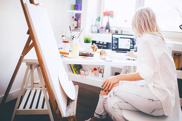 istock Beautiful artist responding to emails on her laptop 530504454