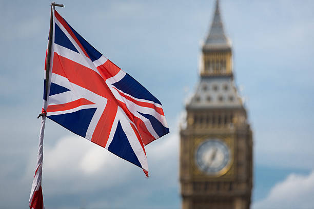 Big Ben and a Union Jack flag London's Big Ben clock tower Westminster street lamp and a Union Jack flag against a blue summer sky. This just shouts out great Britain. No filters were used on this file. Main focus is on the clock tower, union jack flag stock pictures, royalty-free photos & images