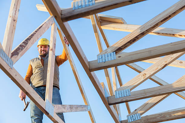 istock Construction worker with hammer on roof of house frame 530505648