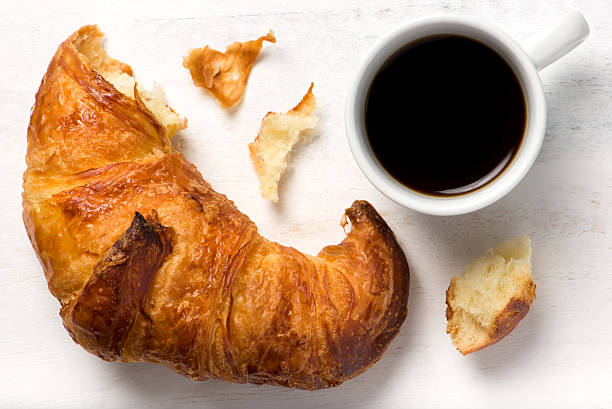 istock fresh croissant and a cup of black coffee 530506713