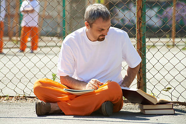 imprisoned 학생 - men reading outdoors book 뉴스 사진 이미지