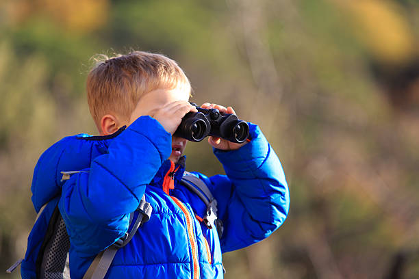 istock little boy with binoculars hiking in mountains 530510122