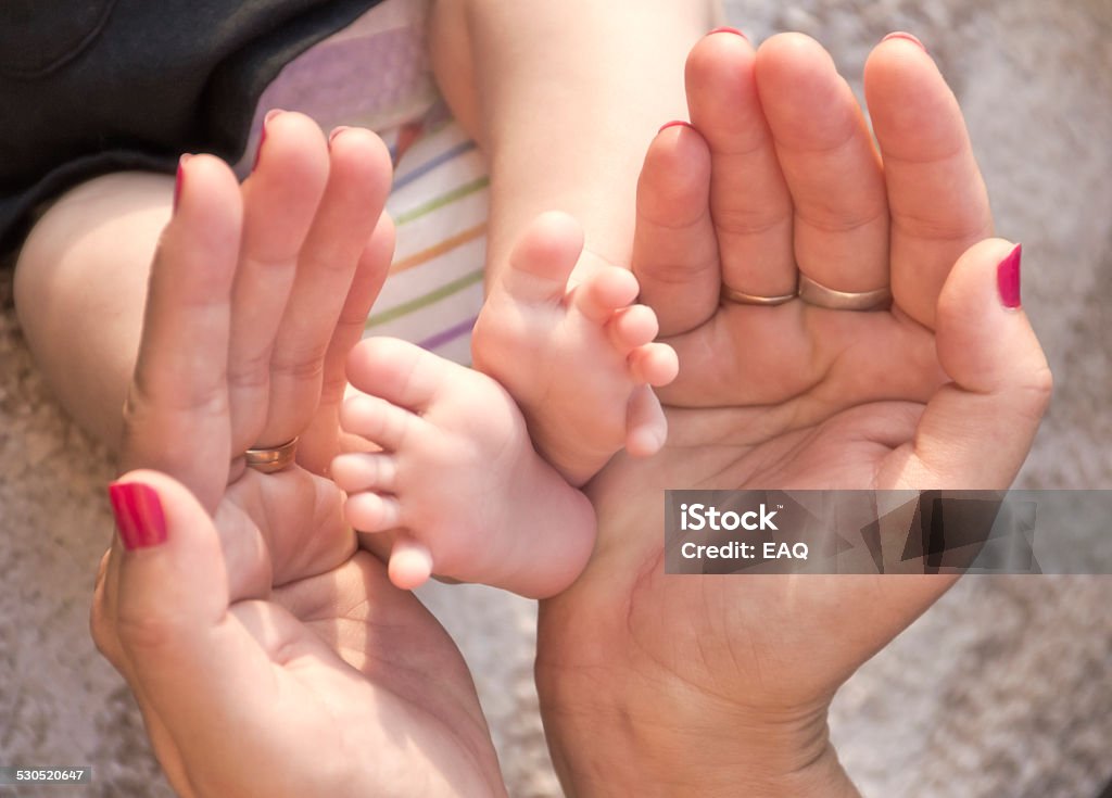 Foot of newborn The baby feet newborn between the hands of your mother. (soft focus). 0-1 Months Stock Photo