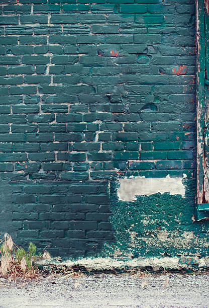 istock Old Damaged Brick Wall painted Green 530521311