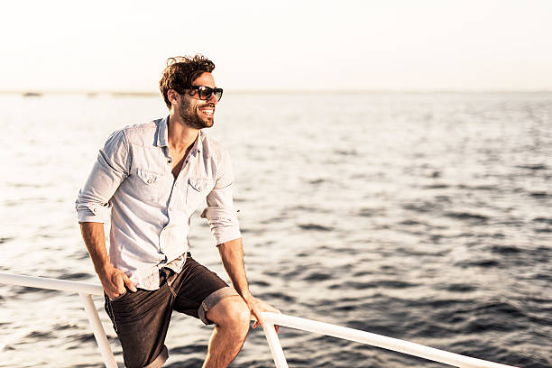 istock Young man enjoying a day on yacht. 530522547