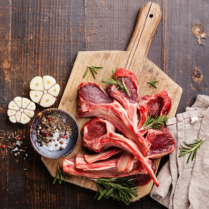 Raw fresh Lamb Meat ribs and seasonings on dark wooden background