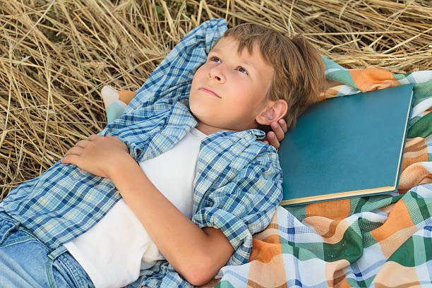 istock Teenage boy lying and thinking inspired by book 530526489