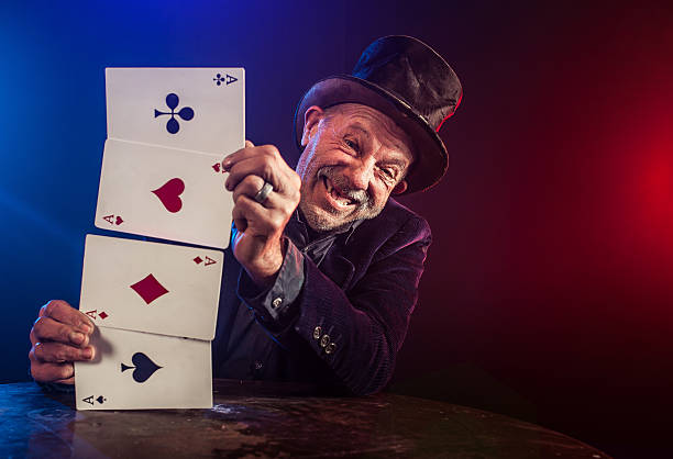 istock Senior man making trick with playing cards 530529135