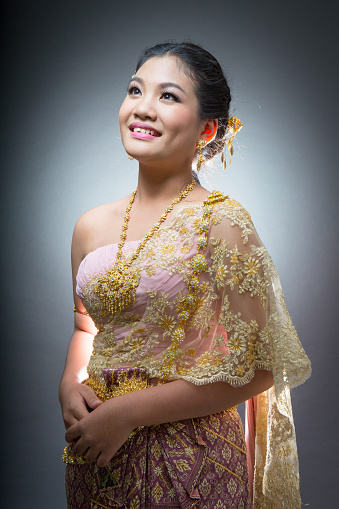 Asian teen age female with traditional Thai suit in Studio on gray background .