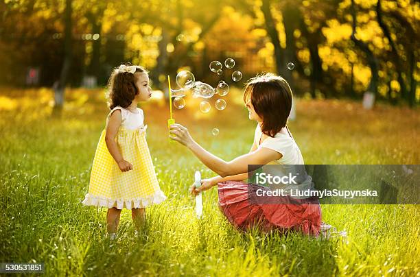Mother And Daughter Playing With Bubbles Stock Photo - Download Image Now - Adult, Autumn, Beautiful People