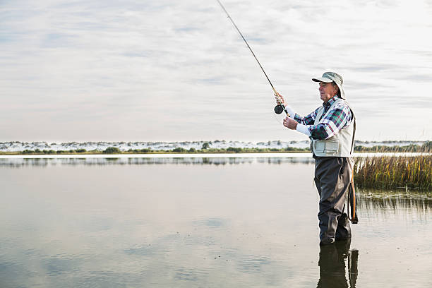 senior homme pêche à la mouche - wading vertical water sport recreational pursuit photos et images de collection