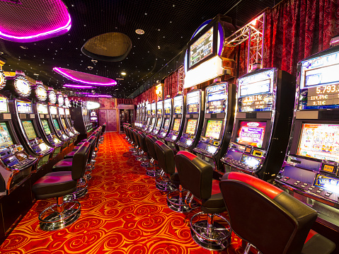 A lot of Slot machines in an empty  Casino.