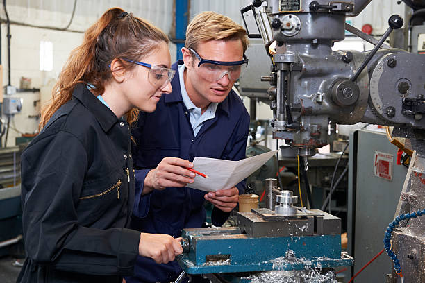 istock Engineer Showing Apprentice How to Use Drill In Factory 530538139